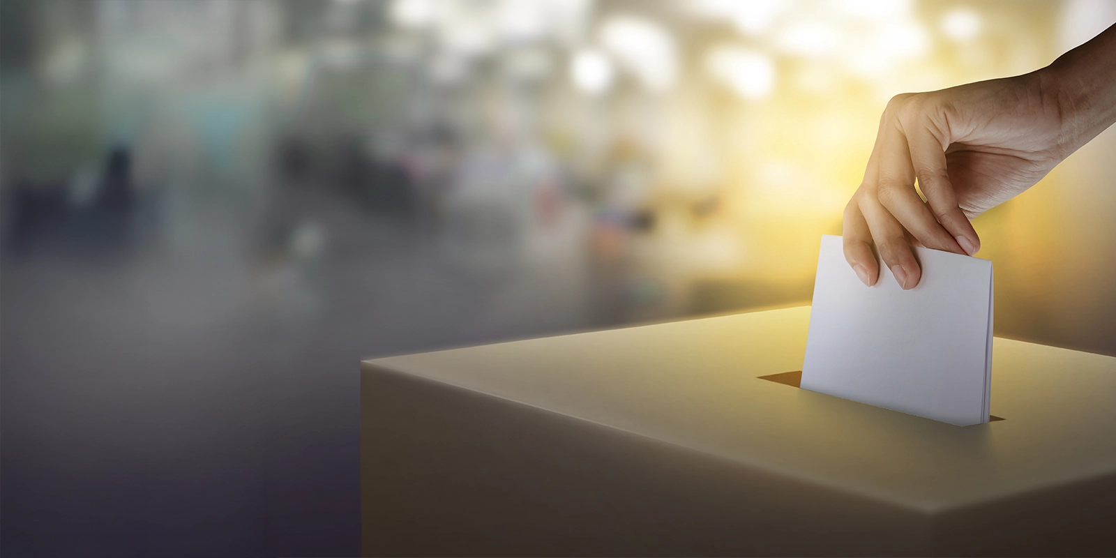 Des femmes mettent à la main du papier avec le vote dans l’urne